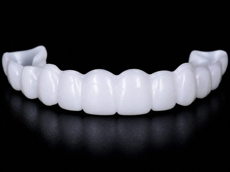 A generic snap-on upper set with identical teeth and a thick plastic ridge at the gumline